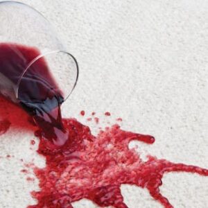 photo of a glass of red wine spilt on white carpet