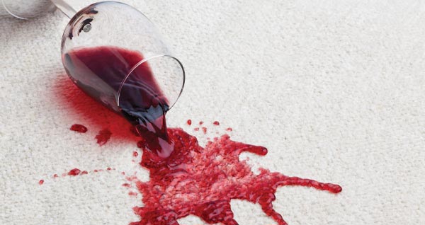 photo of a glass of red wine spilt on white carpet