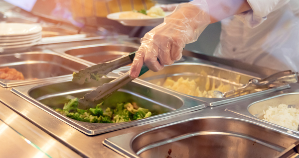 Closeup photo of a lunch person serving food in a cafeteria, bringing back the sweet smell of youth